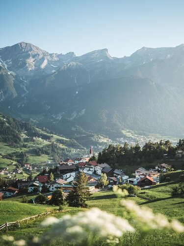 Roman Huber Einige Häuser und im Hintergrund Berge.